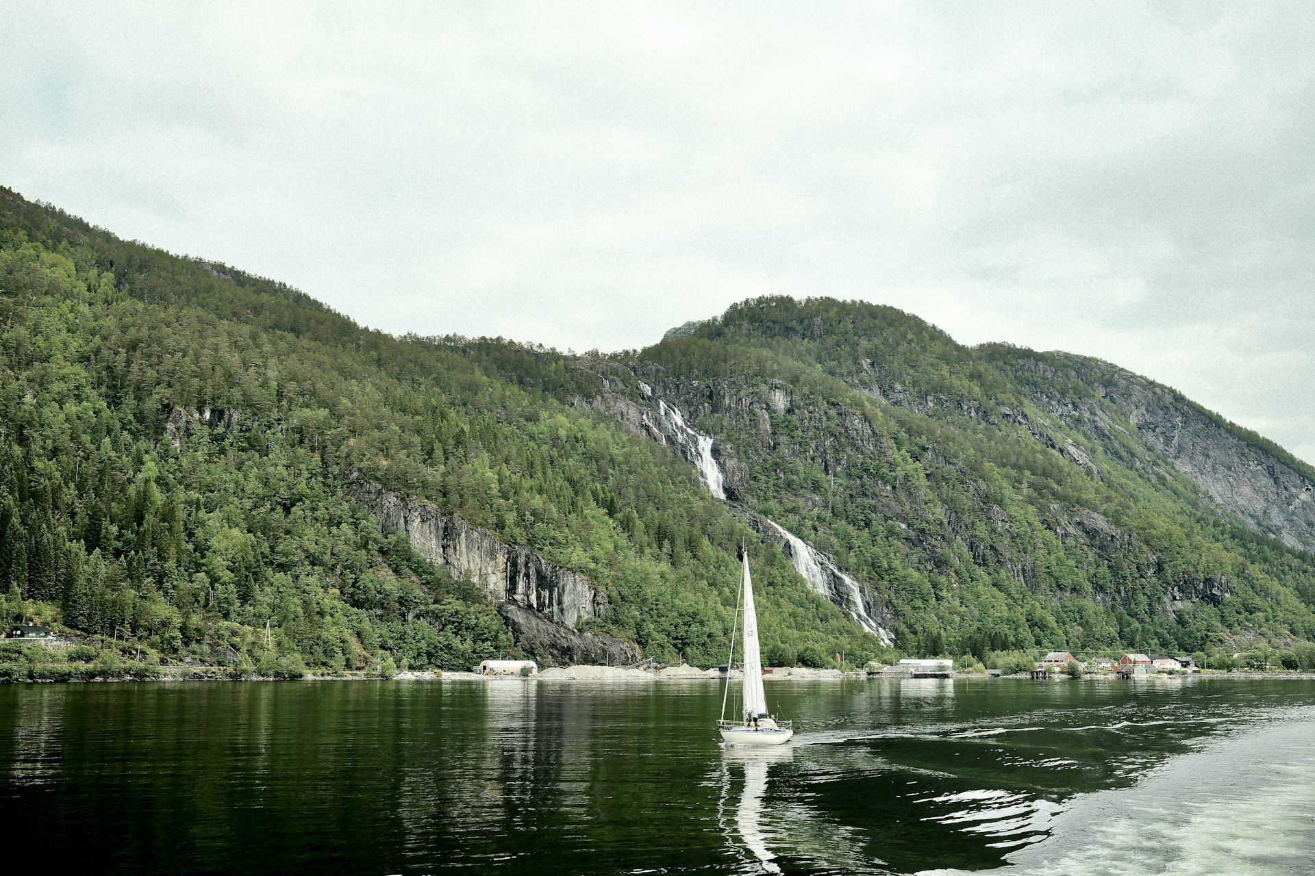 A sailboat underway through a mountain channel